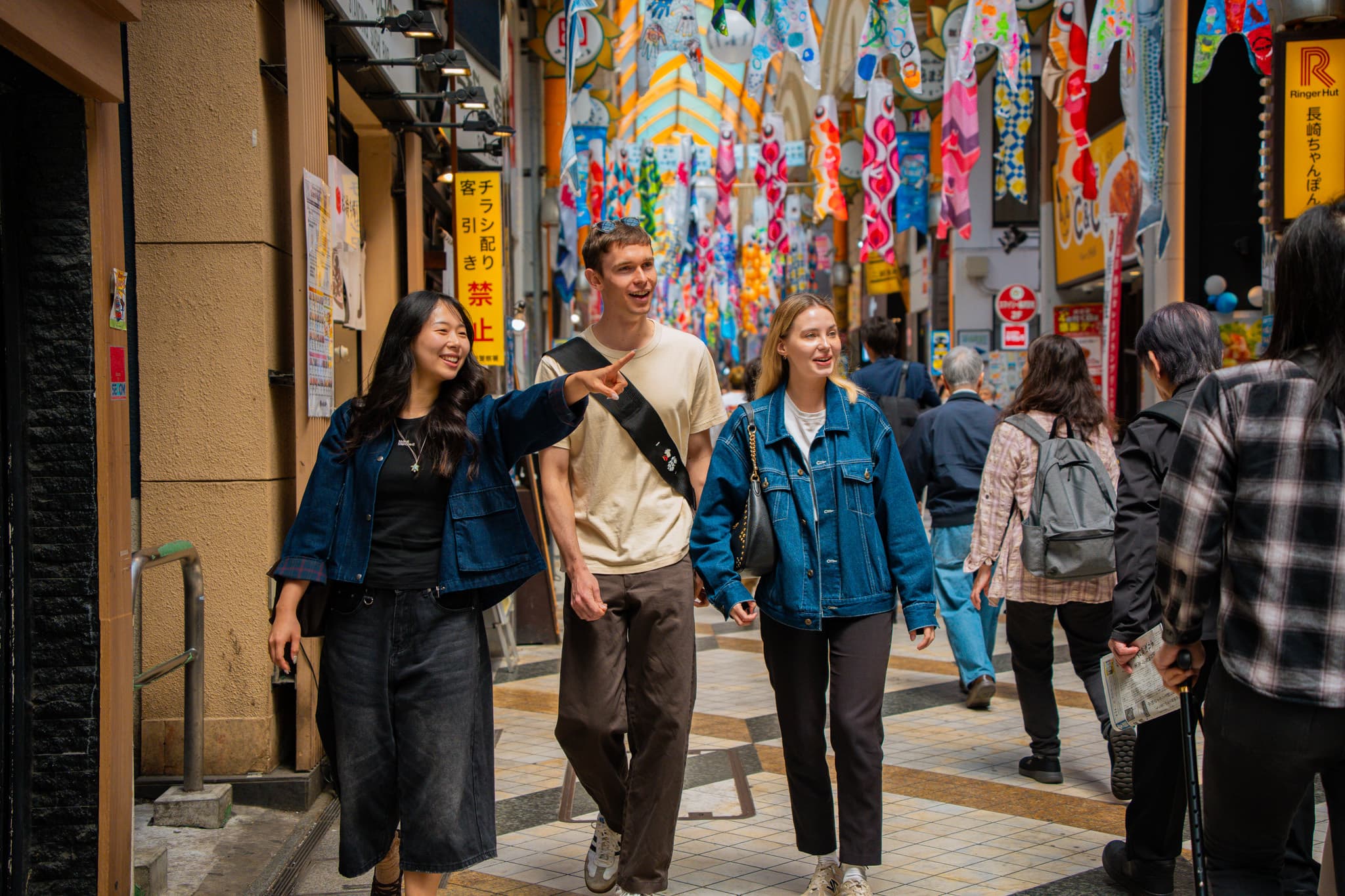 Three travelers walking a covered shopping street in Japan with a Local Expert